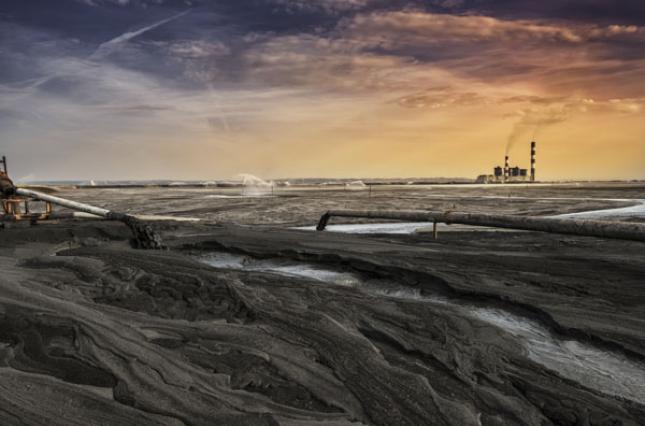 Acres of coal ash with a plant in the background