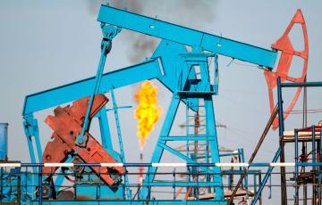 Pumpjacks with a methane flare in the background. Photo credit: Leonid Ikan / Shutterstock